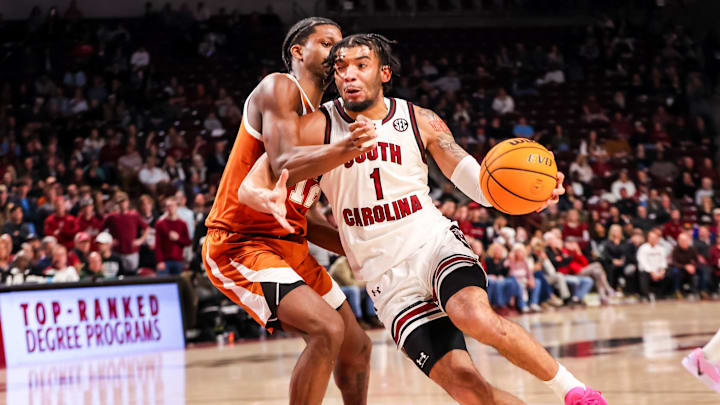 Feb 22, 2025; Columbia, South Carolina, USA; South Carolina Gamecocks guard Jacobi Wright (1) drives past Texas Longhorns guard Tramon Mark (12) in the first half at Colonial Life Arena. Mandatory Credit: Jeff Blake-Imagn Images