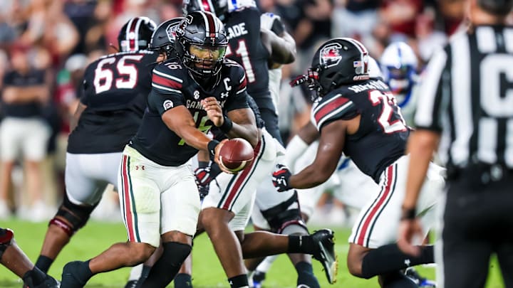 Sep 27, 2025; Columbia, South Carolina, USA; South Carolina Gamecocks quarterback LaNorris Sellers (16) hands off to running back Oscar Adaway III (27) against the Kentucky Wildcats in the second quarter at Williams-Brice Stadium. Mandatory Credit: Jeff Blake-Imagn Images