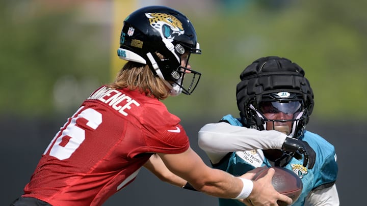 Jacksonville Jaguars quarterback Trevor Lawrence (16) hands off to running back Travis Etienne Jr. (1) during drills on the fifth day of the NFL football training camp practice session Monday, July 29, 2024 at EverBank Stadium's Miller Electric Center in Jacksonville, Fla.. [Bob Self/Florida Times-Union]