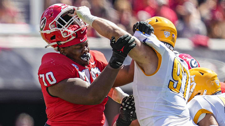 Sep 24, 2022; Athens, Georgia, USA; Georgia Bulldogs offensive lineman Warren McClendon (70) loses his helmet to Kent State Golden Flashes defensive lineman Oliver Billotte (97) at Sanford Stadium. Mandatory Credit: Dale Zanine-Imagn Images