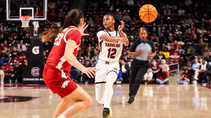 Feb 20, 2025; Columbia, South Carolina, USA; South Carolina Gamecocks guard MiLaysia Fulwiley (12) makes a no-look pass past Arkansas Razorbacks guard Carly Keats (23) in the first half at Colonial Life Arena. Mandatory Credit: Jeff Blake-Imagn Images