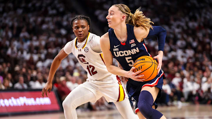 Feb 11, 2024; Columbia, South Carolina, USA; UConn Huskies guard Paige Bueckers (5) drives around South Carolina Gamecocks guard MiLaysia Fulwiley (12) in the second half at Colonial Life Arena. Mandatory Credit: Jeff Blake-Imagn Images