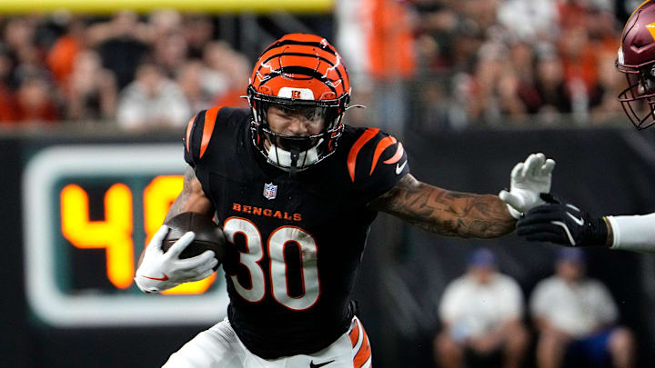 Cincinnati Bengals halfback Chase Brown (30) runs the ball around Washington Commanders linebacker Frankie Luvu (4) Monday, September 23, 2024 at Paycor Stadium.