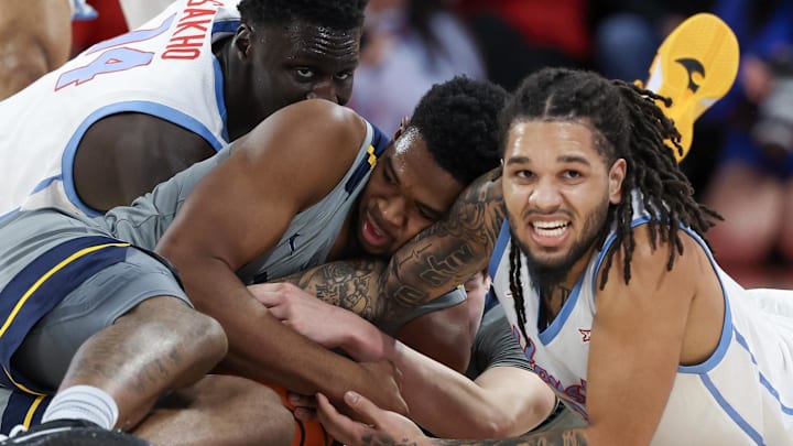 Jan 13, 2026; Houston, Texas, USA; Houston Cougars forward Joseph Tugler (11) and West Virginia Mountaineers forward DJ Thomas (5) reach for a loose ball  in the first half at Fertitta Center. Mandatory Credit: Thomas Shea-Imagn Images