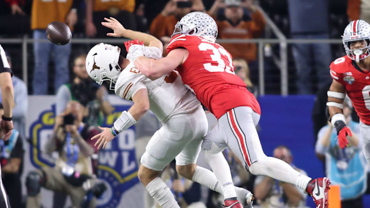 Jan 10, 2025; Arlington, Texas, USA; Ohio State Buckeyes defensive end Jack Sawyer (33) causes a fumble by Texas Longhorns quarterback Quinn Ewers (3) then returns the ball for a touchdown during the fourth quarter of the College Football Playoff semifinal in the Cotton Bowl at AT&T Stadium. Mandatory Credit: Tim Heitman-Imagn Images