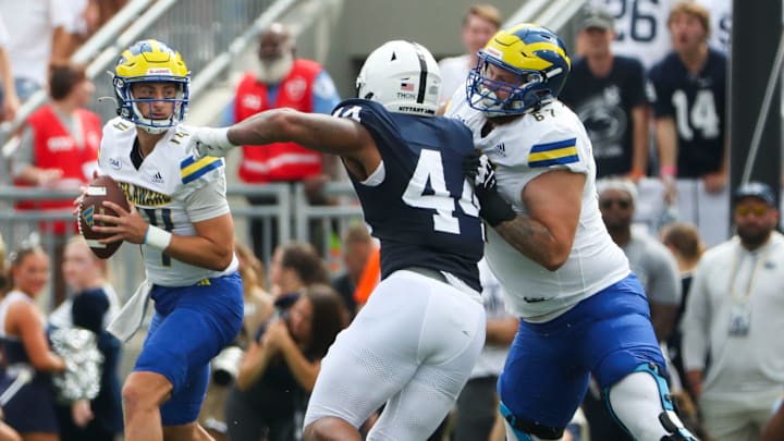 Delaware quarterback Ryan O'Connor (left) works behind blocking from Blaise Sparks (right) against