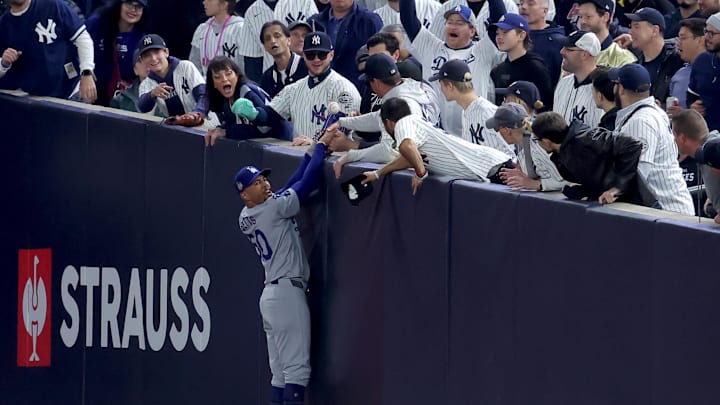 Oct 29, 2024; New York, New York, USA; Los Angeles Dodgers shortstop Mookie Betts (50) makes a catch in foul territory as a New York Yankees fan interferes during the first inning in game four of the 2024 MLB World Series at Yankee Stadium. Mandatory Credit: Brad Penner-Imagn Images