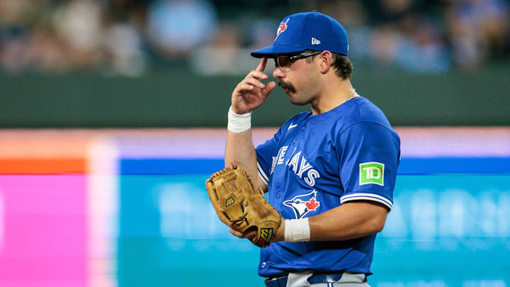 Schneider holds a glove in a blue Blue Jays unifor