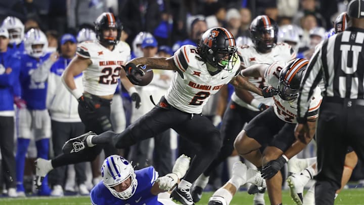 Oct 18, 2024; Provo, Utah, USA; Oklahoma State Cowboys cornerback Korie Black (2) runs after an interception against Brigham Young Cougars offensive lineman Jackson Nelson (54) during the second quarter at LaVell Edwards Stadium. Mandatory Credit: Rob Gray-Imagn Images Oct 18, 2024; Provo, Utah, USA; Oklahoma State Cowboys cornerback Korie Black (2) runs after an interception against Brigham Young Cougars offensive lineman Jackson Nelson (54) during the second quarter at LaVell Edwards Stadium. Mandatory Credit: Rob Gray-Imagn Images