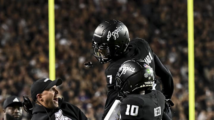 Oct 26, 2024; College Station, Texas, USA; Texas A&M Aggies quarterback Marcel Reed (10) celebrates after scoring a touchdown with Offensive Coordinator/Quarterbacks coach Collin Klein in the third quarter against the LSU Tigers at Kyle Field. Mandatory Credit: Maria Lysaker-Imagn Images. 