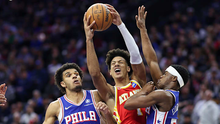 Feb 19, 2026; Philadelphia, Pennsylvania, USA; Atlanta Hawks forward Jalen Johnson (1) drives between Philadelphia 76ers guard Vj Edgecombe (77) and forward Dominick Barlow (25) during the first quarter at Xfinity Mobile Arena. Mandatory Credit: Bill Streicher-Imagn Images