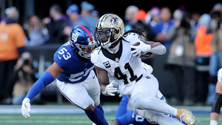 Dec 8, 2024; East Rutherford, New Jersey, USA; New Orleans Saints running back Alvin Kamara (41) runs with the ball against New York Giants linebacker Darius Muasau (53) during the second quarter at MetLife Stadium. Mandatory Credit: Brad Penner-Imagn Images