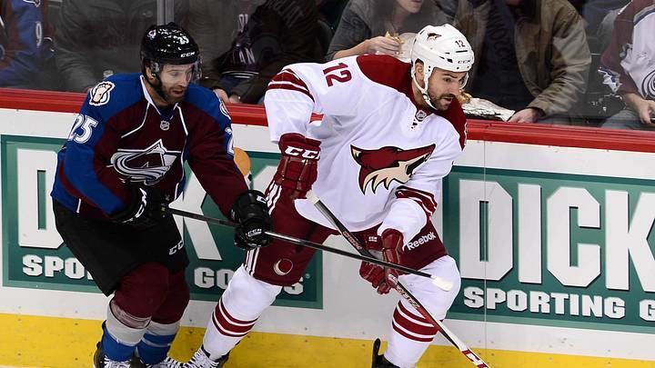 Dec 10, 2013; Denver, CO, USA; Phoenix Coyotes left wing Paul Bissonnette (12) controls the puck away from Colorado Avalanche center Maxime Talbot (25) in the first period at Pepsi Center. Mandatory Credit: Ron Chenoy-Imagn Images Dec 10, 2013; Denver, CO, USA; Phoenix Coyotes left wing Paul Bissonnette (12) controls the puck away from Colorado Avalanche center Maxime Talbot (25) in the first period at Pepsi Center. Mandatory Credit: Ron Chenoy-Imagn Images