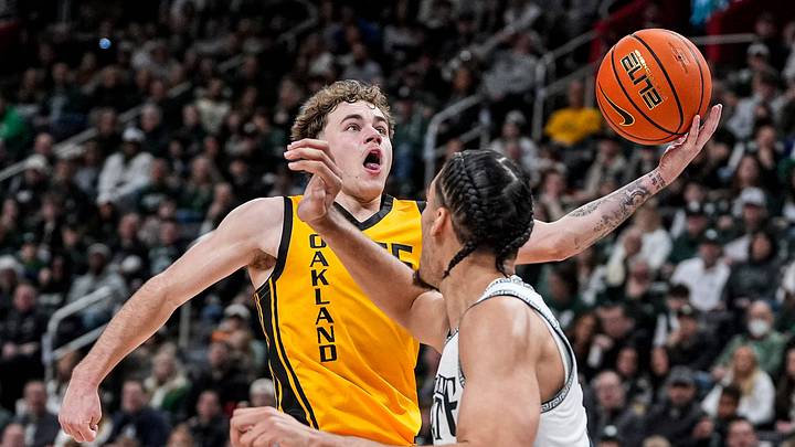 Oakland guard Brody Robinson (55) makes a layup against Michigan State forward Jesse McCulloch (35) during the first half at Little Caesars Arena in Detroit on Saturday, Dec. 20, 2025.