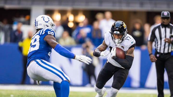 Oct 16, 2022; Indianapolis, Indiana, USA; Jacksonville Jaguars tight end Evan Engram (17) runs with the ball while Indianapolis Colts defensive end Ifeadi Odenigbo (59) defends in the second half at Lucas Oil Stadium. Mandatory Credit: Trevor Ruszkowski-Imagn Images