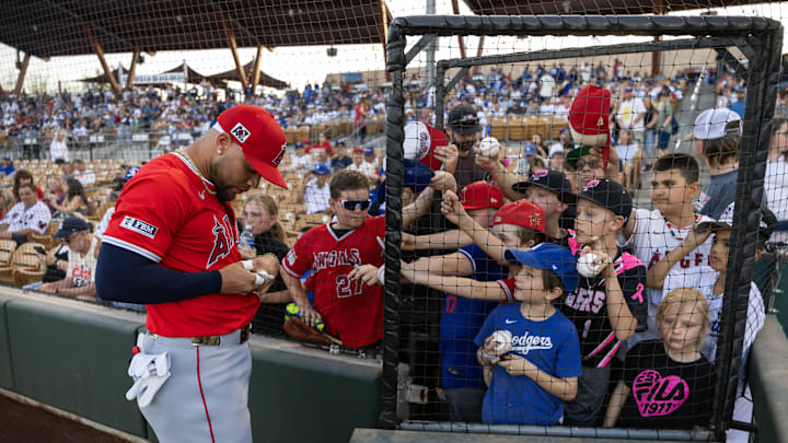 Phoenix, Arizona, USA; Los Angeles Angels third baseman Yoan Moncada signs autographs prior to the game against the Los Angeles Dodgers during spring training at Camelback Ranch-Glendale. 