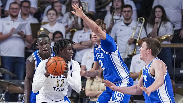 Dec 21, 2024; Atlanta, Georgia, USA; Georgia Tech Yellow Jackets forward Baye Ndongo (11) looks to pass against Duke Blue Devils guard Cooper Flagg (2) and guard Kon Knueppel (7) during the first half at McCamish Pavilion. Mandatory Credit: Dale Zanine-Imagn Images