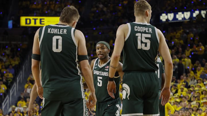 Feb 21, 2025; Ann Arbor, Michigan, USA; Michigan State Spartans guard Tre Holloman (5) talks with forward Jaxon Kohler (0) and center Carson Cooper (15) during the second half at Crisler Center. Mandatory Credit: Brian Bradshaw Sevald-Imagn Images