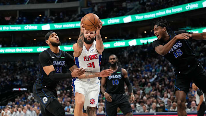 Apr 12, 2024; Dallas, Texas, USA; Detroit Pistons guard Evan Fournier (31)grabs a rebound between Dallas Mavericks center Daniel Gafford (21) and forward Olivier-Maxence Prosper (18) during the first half at American Airlines Center. Mandatory Credit: Chris Jones-USA TODAY Sports