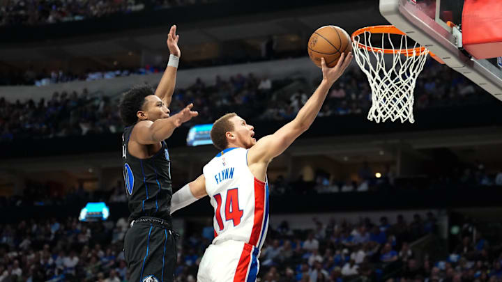 Apr 12, 2024; Dallas, Texas, USA; Detroit Pistons guard Malachi Flynn (14) scores a layup against Dallas Mavericks guard Brandon Williams (00) during the second half at American Airlines Center. Mandatory Credit: Chris Jones-USA TODAY Sports