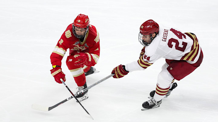 Apr 13, 2024; Saint Paul, Minnesota, USA; Denver Pioneers defenseman Sean Behrens (2) and Boston College Eagles forward Andre Gasseau (24) compete for the puck during the second period of the championship game of the 2024 Frozen Four college ice hockey tournament at Xcel Energy Center. Mandatory Credit: Matt Krohn-Imagn Images