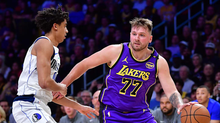 Feb 25, 2025; Los Angeles, California, USA; Los Angeles Lakers guard Luka Doncic (77) dribbles the ball past Dallas Mavericks guard Max Christie (00) during the second half at Crypto.com Arena. Mandatory Credit: Gary A. Vasquez-Imagn Images