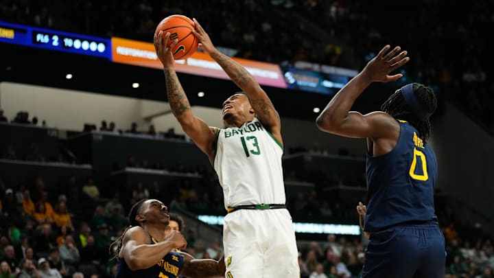 Feb 15, 2025; Waco, Texas, USA; Baylor Bears guard Langston Love (13) drives to the basket ahead of West Virginia Mountaineers center Eduardo Andre (0) during the first half at Paul and Alejandra Foster Pavilion. Feb 15, 2025; Waco, Texas, USA; Baylor Bears guard Langston Love (13) drives to the basket ahead of West Virginia Mountaineers center Eduardo Andre (0) during the first half at Paul and Alejandra Foster Pavilion.