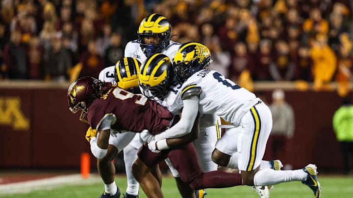 Oct 7, 2023; Minneapolis, Minnesota, USA; Minnesota Golden Gophers wide receiver Daniel Jackson (9) is tackled by a crowd of Michigan Wolverines during the second quarter at Huntington Bank Stadium. Mandatory Credit: Matt Krohn-Imagn Images