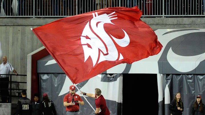 Sep 29, 2017; Pullman, WA, USA; Washington State Cougars cheerleader waves a school flag during a game against the USC Trojans at Martin Stadium. Mandatory Credit: James Snook-Imagn Images