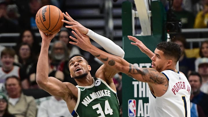 Feb 27, 2025; Milwaukee, Wisconsin, USA;  Milwaukee Bucks forward Giannis Antetokounmpo (34) grabs a rebound against Denver Nuggets forward Michael Porter Jr. (1) in the first quarter at Fiserv Forum. Mandatory Credit: Benny Sieu-Imagn Images
