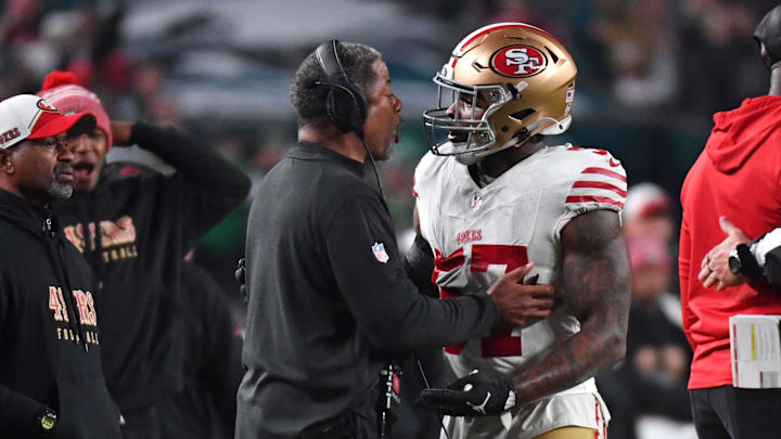 Dec 3, 2023; Philadelphia, Pennsylvania, USA; San Francisco 49ers linebacker Dre Greenlaw (57) talks a with a coach after being ejected against the Philadelphia Eagles during the third quarter at Lincoln Financial Field. Mandatory Credit: Eric Hartline-Imagn Images