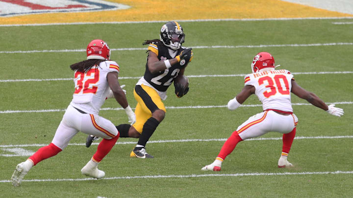 Dec 25, 2024; Pittsburgh, Pennsylvania, USA;  Pittsburgh Steelers running back Najee Harris (22) runs the ball as Kansas City Chiefs linebacker Nick Bolton (32) and cornerback Christian Roland-Wallace (30) defend during the third quarter at Acrisure Stadium. Mandatory Credit: Charles LeClaire-Imagn Images