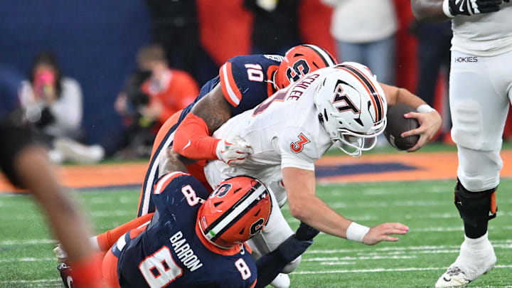 Nov 2, 2024; Syracuse, New York, USA; Virginia Tech Hokies quarterback Collin Schlee (3) is tackled by Syracuse Orange defensive back Justin Barron (8) and defensive lineman Fadil Diggs (10) in the second quarter at JMA Wireless Dome. Mandatory Credit: Mark Konezny-Imagn Images Nov 2, 2024; Syracuse, New York, USA; Virginia Tech Hokies quarterback Collin Schlee (3) is tackled by Syracuse Orange defensive back Justin Barron (8) and defensive lineman Fadil Diggs (10) in the second quarter at JMA Wireless Dome. Mandatory Credit: Mark Konezny-Imagn Images