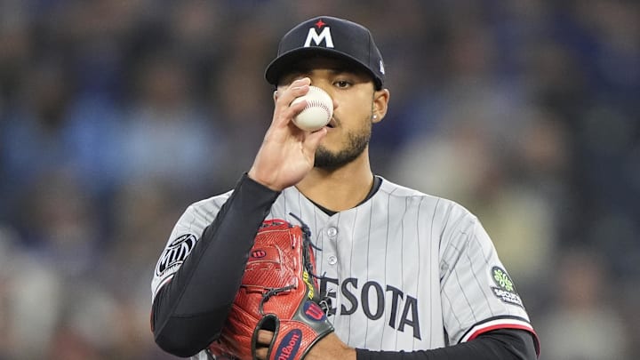 Apr 12, 2026; Toronto, Ontario, CAN; Minnesota Twins starting pitcher Taj Bradley (26) inspects a baseball before throwing a pitch to the Toronto Blue Jays during the first inning at Rogers Centre. Mandatory Credit: John E. Sokolowski-Imagn Images