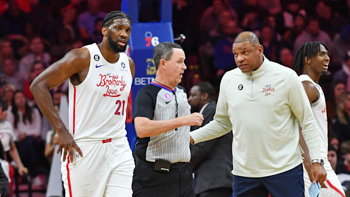 Jan 12, 2023; Philadelphia, Pennsylvania, USA;Philadelphia 76ers head coach Doc Rivers and center Joel Embiid (21) question referee Matt Boland (18) against the Oklahoma City Thunder during the first quarter at Wells Fargo Center. Mandatory Credit: Eric Hartline-Imagn Images