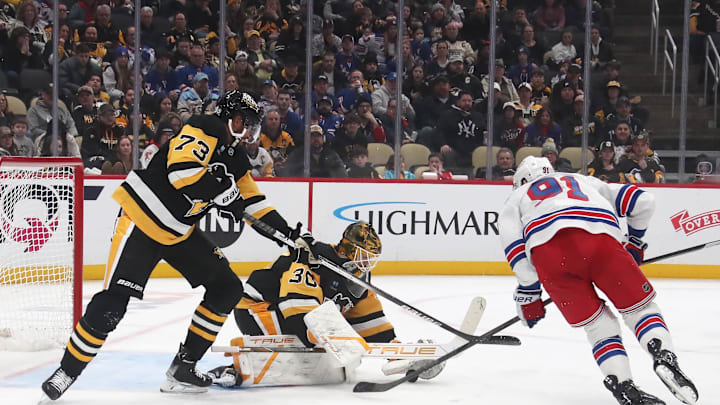 Feb 23, 2025; Pittsburgh, Pennsylvania, USA;  Pittsburgh Penguins goaltender Joel Blomqvist (30) makes a save against New York Rangers right wing Reilly Smith (91) as Penguins defenseman P.O Joseph (73) assists in defending during the third period at PPG Paints Arena. Mandatory Credit: Charles LeClaire-Imagn Images