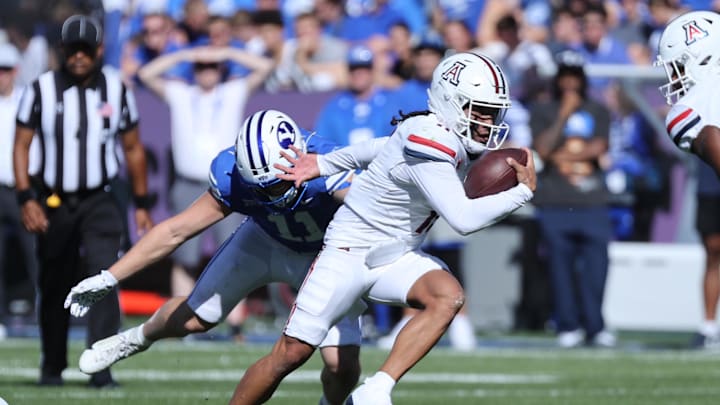 Oct 12, 2024; Provo, Utah, USA; Arizona Wildcats quarterback Noah Fifita (11) runs from Brigham Young Cougars linebacker Harrison Taggart (11) during the second quarter at LaVell Edwards Stadium. Mandatory Credit: Rob Gray-Imagn Images