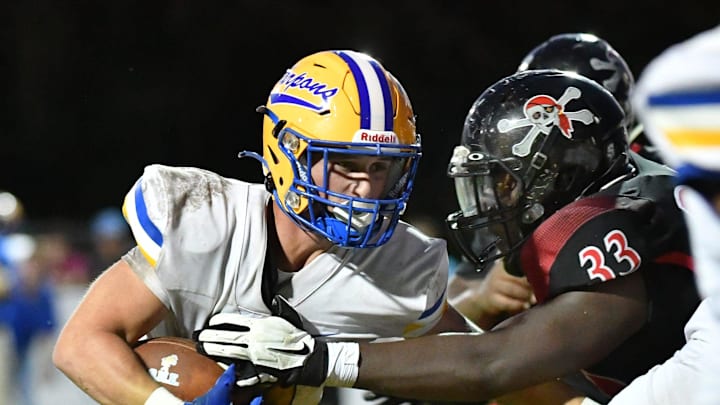 Charlotte High running back Connor Trim (#21) is met at the line of scrimmage by Port Charlotte