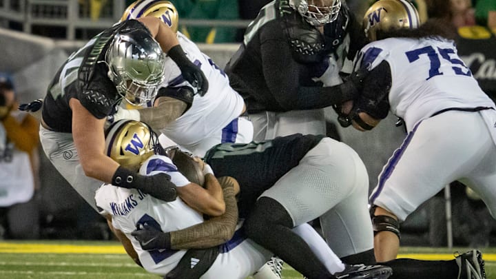 Oregon outside linebackers Matayo Uiagalelei, right, and Teitum Tuioti, left, sack Washington quarterback Demond Williams Jr. as the No. 1 Oregon Ducks host the Washington Huskies Saturday, Nov. 30, 2024 at Autzen Stadium in Eugene, Ore.