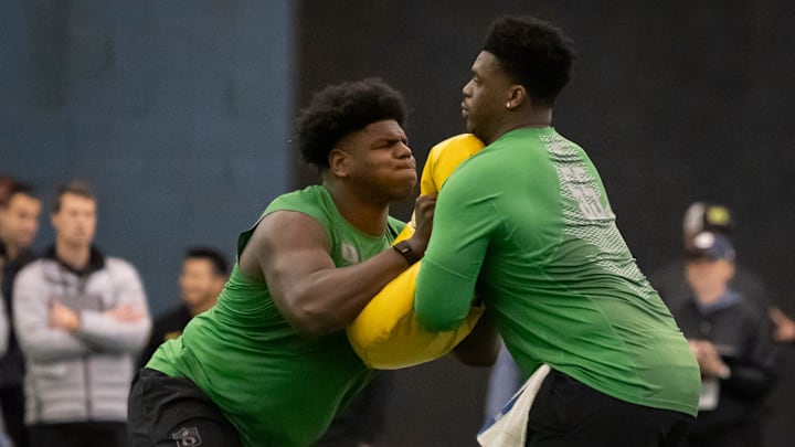 Oregon offensive lineman Josh Conerly Jr., left, runs drills with Oregon offensive lineman Marcus Harper II.
