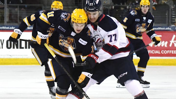 Erie Otters forward Dylan Edwards, leftt, competes against Saginaw Spirit forward Michael Misa during an Ontario Hockey League playoff game at Erie Insurance Arena in Erie on April 1, 2025.