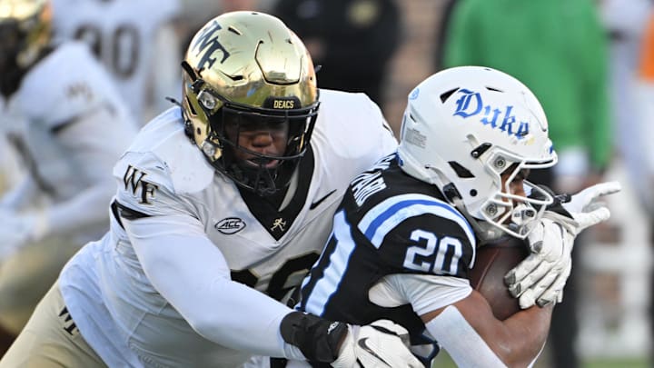 Wake Forest Demon Deacons defensive lineman Mateen Ibirogba (99) tackles Duke Blue Devils running back Nate Sheppard (20) during the first quarter at Wallace Wade Stadium.