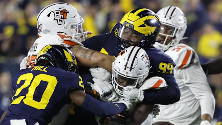 Sep 16, 2023; Ann Arbor, Michigan, USA; Bowling Green Falcons running back PaSean Wimberly (30) is tackled by Michigan Wolverines defensive lineman Cam Goode (99) and defensive back Jyaire Hill (20) in the second half at Michigan Stadium. Mandatory Credit: Rick Osentoski-USA TODAY Sports