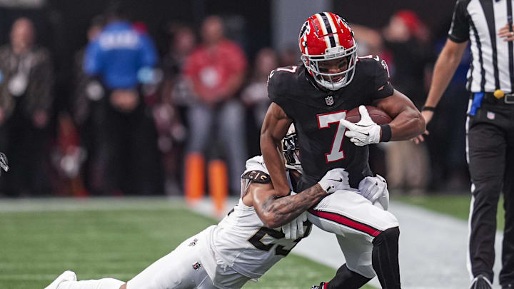 Sep 29, 2024; Atlanta, Georgia, USA; Atlanta Falcons running back Bijan Robinson (7) runs against New Orleans Saints cornerback Marshon Lattimore (23) during the first quarter at Mercedes-Benz Stadium. Mandatory Credit: Dale Zanine-Imagn Images