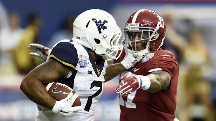 Aug 30, 2014; Atlanta, GA, USA; West Virginia Mountaineers running back Rushel Shell (7) stiff arms Alabama Crimson Tide running back Kenyan Drake (17) on a kick off during the third quarter of the 2014 Chick-fil-a kickoff game at Georgia Dome. Mandatory Credit: John David Mercer-Imagn Images