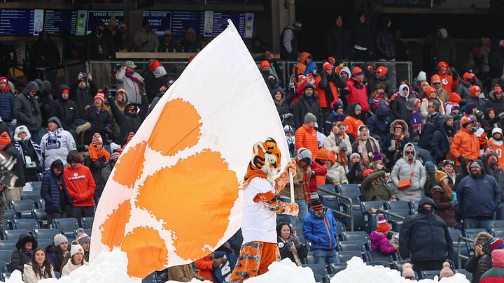 Dec 27, 2025; Bronx, NY, USA; The Clemson Tiger waves a flag while standing on a snow pile during the second half of the 2025 Pinstripe Bowl against the Penn State Nittany Lions at Yankee Stadium. Mandatory Credit: Vincent Carchietta-Imagn Images