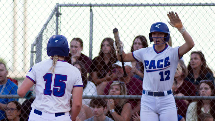 Pace High School's Britten Kettler (No. 12) celebrates as teammate Kamryn Pierce (No. 15) scores a run during the Region 1-6 championship game against Navarre on May 15, 2026. The Lady Patriots dominated the Lady Radier, 11-0, to advance to the state final four.