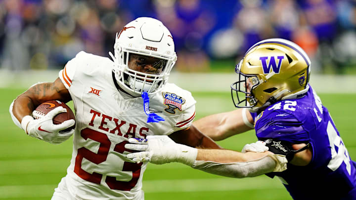 Jan 1, 2024; New Orleans, LA, USA; Texas Longhorns running back Jaydon Blue (23) runs the ball against Washington Huskies linebacker Carson Bruener (42) during the fourth quarter in the 2024 Sugar Bowl college football playoff semifinal game at Caesars Superdome. 