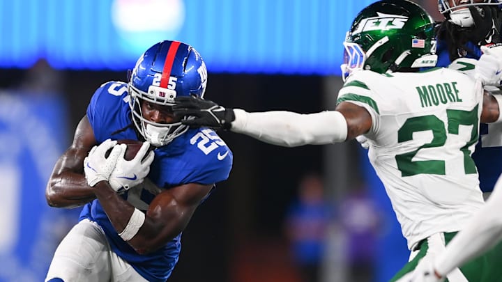 Aug 16, 2025; East Rutherford, New Jersey, USA; New York Giants running back Dante Miller (25) runs against New York Jets safety Malachi Moore (27) defends during the second half at MetLife Stadium.  