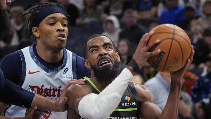 Feb 1, 2025; Minneapolis, Minnesota, USA; Minnesota Timberwolves guard Mike Conley (10) goes to the basket past Washington Wizards guard Carlton Carrington (8) in the fourth quarter at Target Center. Mandatory Credit: Bruce Kluckhohn-Imagn Images